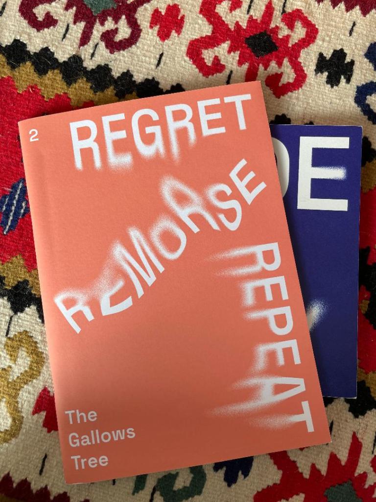 Photograph of the literary journal The Gallows Tree, issue #1 (blue) and #2 (red) photographed on carpet.